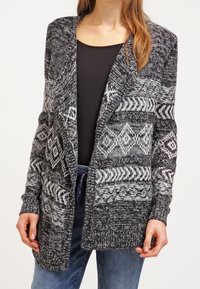 Stickad kofta i svart och grått med geometriska mönster, öppen framdesign, långa ärmar och ribbade muddar. Texturerad tyg.