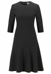 Svart klänning i slätt tyg, med rund halsringning, trekvartslånga ärmar och en utsvängd nederkant med en sömdetalj vid midjan.