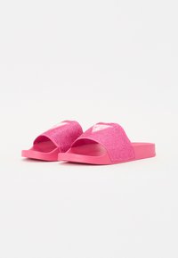 Rosa Rutschsandaletten mit einem strukturierten, funkelnden Riemen und fester Sohle. Mit einem Logo auf dem Riemen; offene Zehenpartie für einfaches Tragen.