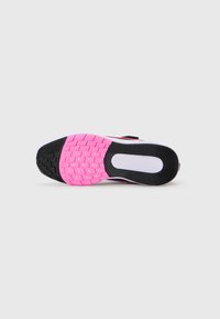 Semelle d'une chaussure de sport montrant un motif de caoutchouc noir et rose avec des grips en forme d'étoile sur un fond blanc.