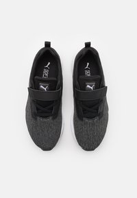 Baskets en tissu noires et grises avec une tige texturée, une lanière noire et une semelle en caoutchouc blanche. Elles sont dotées de lacets noirs et d'un logo sur la languette.