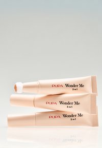 Pupa Wonder Me 3-in-1 Creme mit einem weichen Applikator. Glatte, leichte Verpackung in Pfirsichfarbe mit schwarzem Text. Verfügt über eine reflektierende Oberfläche.