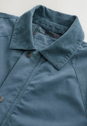 Light blue jacket with a corduroy collar, snap button closure, and textured fabric. Features inner plaid lining and regular fit design.