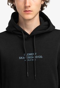 Felpa nera con cappuccio realizzata in tessuto morbido, presenta un logo frontale in azzurro chiaro che recita "ELEMENT SKATEBOARD CO. WORLD WIDE." Include anche i lacci per la regolazione.