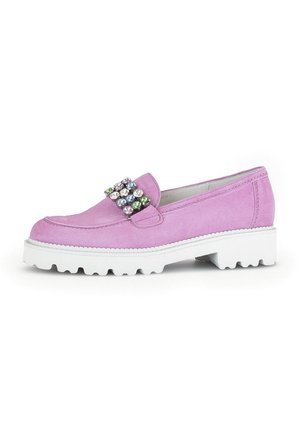 Pink suede slip-on shoe with white rubber sole, featuring a jeweled accent on the front. Round toe and textured surface with stitching detail.