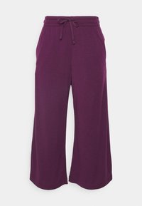 Lila vida byxor i mjukt tyg med elastisk midja och dragband. Slät textur utan synliga mönster eller detaljer.