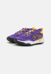 Lila Sport Sneakers mit gelben Akzenten und Schnürsenkeln, ausgestattet mit einer strukturierten Sohle und einem PUMA-Logo an der Seite. Mesh-Obermaterial für Atmungsaktivität.