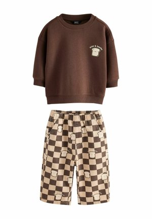 Brun sweatshirt med "nice & toasty" toast-grafik og beige og brune ternede shorts med toastillustrationer.