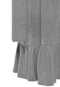 Měkká šedá látková sukénka s nařaseným volánkem a dlouhým rukávem na bílé pozadí.