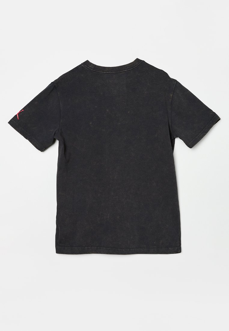 Maglietta nera in cotone con scollo rotondo e maniche corte. Presenta una texture sbiadita e un piccolo logo rosso sulla manica sinistra.