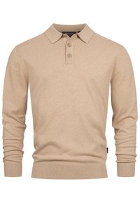 Camisa polo de manga larga beige hecha de tejido suave, presenta un cuello clásico y una tapeta de tres botones, con puños y dobladillo acanalados.