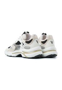 Baskets avec une tige en maille et en daim beige et noir, dotées d'un panneau latéral transparent, de lacets blancs et d'une semelle accentuée de doré.