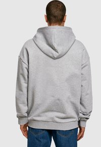 Gray, oversized hoodie with a drawstring hood and ribbed cuffs and hem. Soft material, featuring a seamless back design.