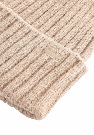 Beige ribota adīta cepure, izgatavota no teksturēta auduma, ar mazu logotipa uzlīmi. Mīksts, elastīgs materiāls ar ciešu piegulšanu.