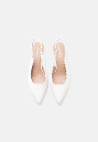Chaussures à bride arrière en satin blanc avec un bout pointu, ornées d'un bord décoratif en perles le long du design découpé. Doublure intérieure douce visible.