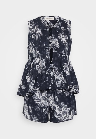 Top sans manches à imprimé floral avec un design à peplum, associé à un short assorti. Schéma de couleurs bleu marine et blanc, en tissu léger.