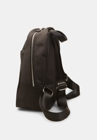 Mochila de tela negra con una textura suave, que cuenta con un bolsillo frontal con cremallera, correas ajustables y acentos de hardware metálico.