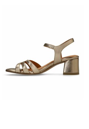 Goldene Sandale mit niedrigem Blockabsatz, drei vorderen Riemen und Knöchelriemen mit Schnallenverschluss, Seitenansicht.