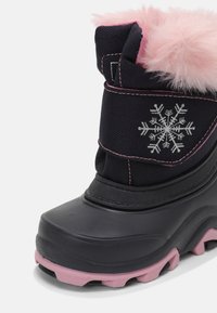 Botte d’hiver noire et rose pour enfant avec semelle à crampons, doublure en fausse fourrure rose et flocon de neige argenté brodé sur le côté extérieur.