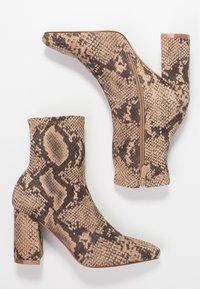 Beige a hnědé kotníkové boty se vzorem hada, vysoký blokový podpatek a boční zip; hladká textura a špičatý design špičky.