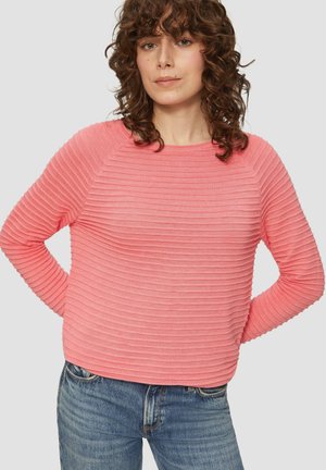 Roze geribde trui met een ronde halslijn en lange mouwen, met textuurstrepen. Gecombineerd met blauwe denim jeans.