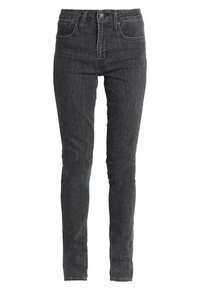 Vaqueros skinny negros de denim, con cintura alta, diseño de cinco bolsillos y un cierre clásico de botón y cremallera.