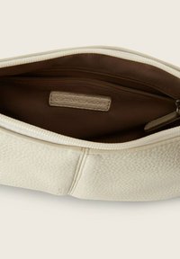 Borsa a pochette di colore crema con chiusura a zip. L'interno presenta una fodera marrone e una piccola tasca con zip. Etichetta del marchio visibile.
