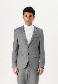 Grå teksturert dress med to knapper, notched lapels og to frontlommer. Kombinert med en hvit dresskjorte. Ren, skreddersydd passform.