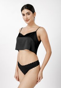 Μαύρο σατέν τοπ κοντό με λεπτές τιράντες σπαγγέτι και κυματιστό τελείωμα. Συνδυάζεται με μαύρο μαγιό σλιπ με κυματιστή άκρη.