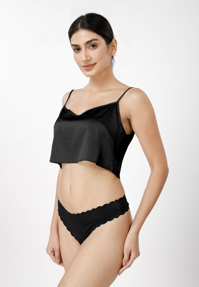 Μαύρο σατέν τοπ κοντό με λεπτές τιράντες σπαγγέτι και κυματιστό τελείωμα. Συνδυάζεται με μαύρο μαγιό σλιπ με κυματιστή άκρη.