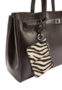 Brązowa skórzana torba typu tote o wyraźnej strukturze, wyposażona w odpinaną kieszeń na zamek z czarno-białym wzorem zebry.