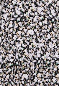 Svart tyg med ett blommönster som har vita, krämfärgade och dämpade gröna blommor. Texturerade veck vid nederkanten ger dimension.