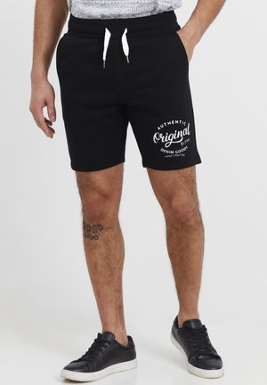 Shorts en mélange de coton noir avec une taille élastique, un cordon blanc et un logo imprimé "Authentic Original" sur la cuisse gauche.