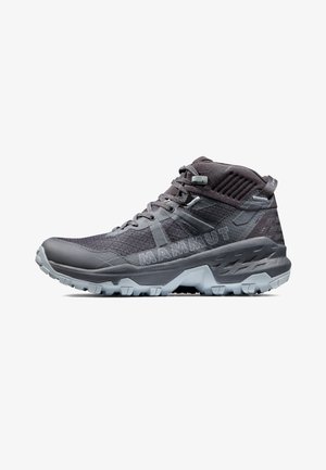 Szare buty trekkingowe z teksturowanym wierzchem, wysokim wsparciem kostki oraz wytrzymałą podeszwą z wyraźnymi wypustkami zapewniającymi dobrą przyczepność. Wyraźny detal z logo.