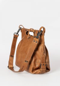 Bruine leren tas met een zachte textuur, voorzien van een korte bovenhandgreep en een verstelbare schouderband, met metalen hardware accenten.