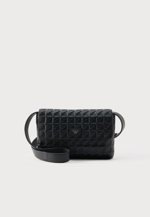 Zwarte crossbodytas met een gestructureerd oppervlak, een klepsluiting en een klein metalen logo aan de voorkant, afgebeeld tegen een effen achtergrond.