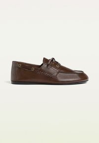 Bruna läder slip-on skor med en slät yta, rund tå och dekorativ sömnad. Har guldtonade öglor och en minimalistisk design.