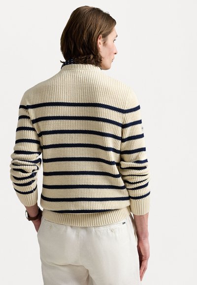 Pull en maille crème à col rond avec des rayures horizontales bleu marine, doté de bords-côtes aux poignets et à l'ourlet, avec une finition texturée.