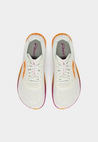 Ζευγάρι λευκών αθλητικών παπουτσιών με δίχτυ, με πορτοκαλί και μωβ σόλες, δεμένα κορδόνια και πορτοκαλί λογότυπο στα πλαϊνά, σε άποψη από πάνω.