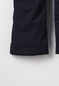 Navyblauwe waterdichte outdoorbroek met een rechte pasvorm, versterkte zoom en een oranje accent op de zijzak.