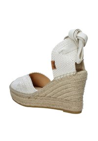Sandalo espadrilles a zeppa intessuto bianco con superficie testurizzata, suola in juta naturale e cinturino in tessuto alla caviglia annodato a fiocco.