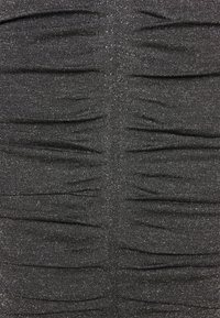 Svart texturerad tyg med horisontell rynkning och subtila glittriga detaljer som skapar en lager-liknande effekt. Slät yta, elastiskt material.