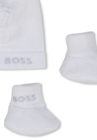 Calzini per bambina in cotone bianco con dettaglio a costine, caratterizzati dal nome del marchio "BOSS" in grigio chiaro in rilievo. Design morbido e flessibile.