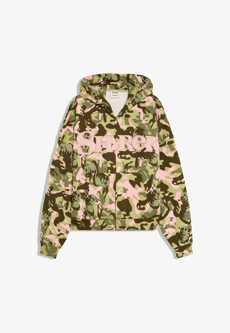 Veste à capuche zippée avec motif camouflage vert et rose et grandes lettres roses "SHREK" sur le devant.