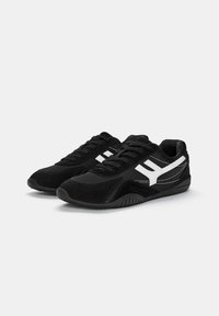 Pantofi sport negri, realizati din materiale de piele intoarsa si plasa, cu accente albe si dungi. Design cu sireturi si talpa din cauciuc texturat.
