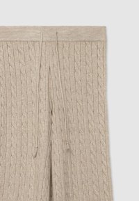 Pantaloni beige in maglia con motivo a trecce, vita elastica con coulisse e tessuto strutturato.