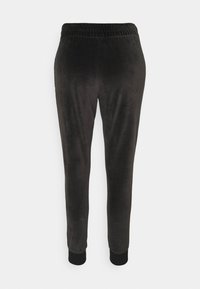 Svarta velour joggerbyxor med en mjuk textur, elastisk midja och åtsittande mudd vid anklarna. Inga synliga fickor eller hårdvarudetaljer.