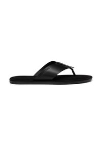Sandale noire en cuir avec semelle plate et large bride portant le nom de la marque embossé sur le côté, vue de profil.