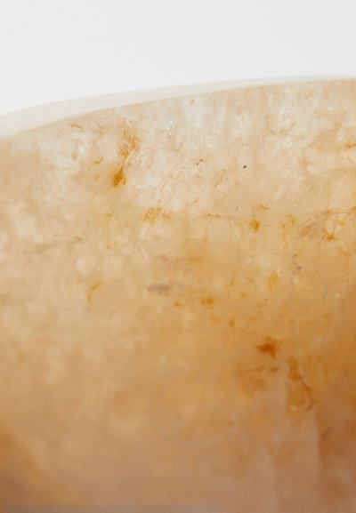 Prozirni jantar s glatkom površinom. Sadrži suptilne žile i pjege žute i smeđe boje, prikazujući prirodnu mineralnu teksturu.