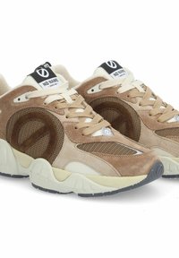 Beige und braune Sneakers mit Obermaterial aus Wildleder und Mesh, kontrastierenden Nähten, runder Zehenpartie und einer klobigen weißen Sohle mit schwarzen Akzenten.